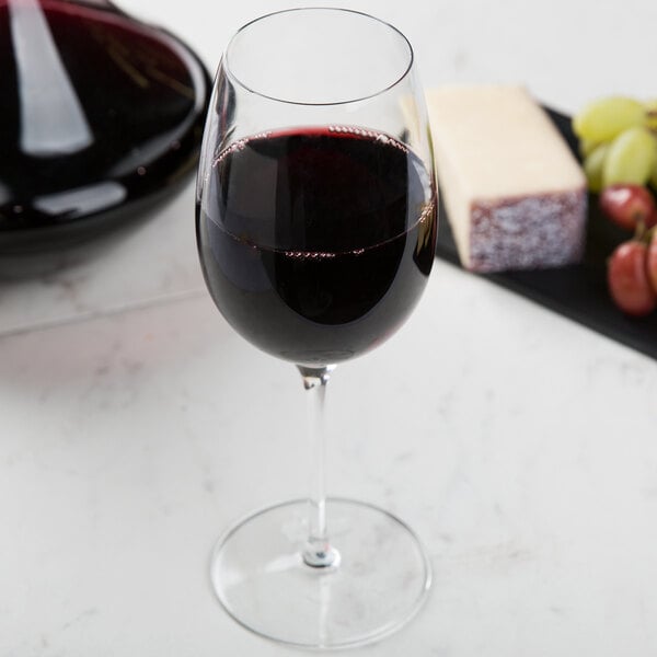 A Reserve by Libbey Renaissance wine glass filled with red wine on a table.