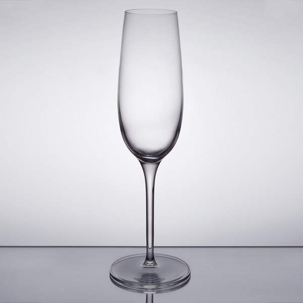 A clear glass champagne flute with a stem.