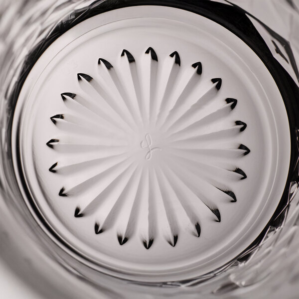 A close-up view of the bottom of a Libbey Ocular 14 oz. beverage glass featuring a decorative pattern.