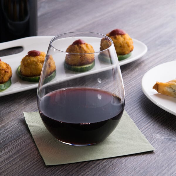 A Reserve by Libbey Renaissance stemless red wine glass on a table with food.