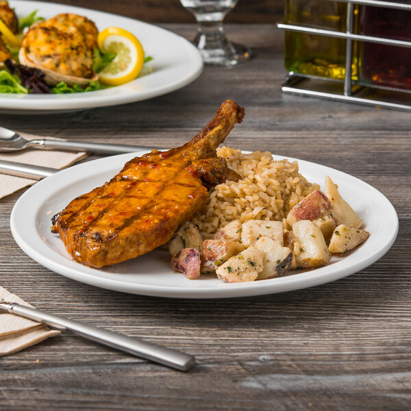 A Libbey Porcelana narrow rim porcelain plate with food on a table.