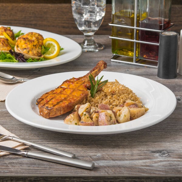 A Libbey Porcelana white plate with a meal on a table with silver utensils.