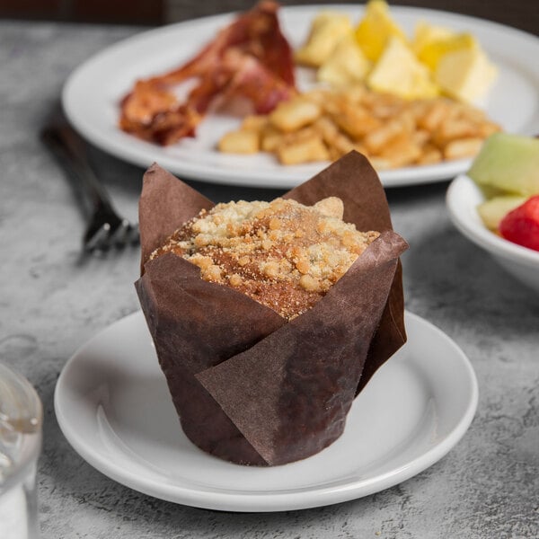 A Libbey Porcelana white plate with a muffin and breakfast food on it.