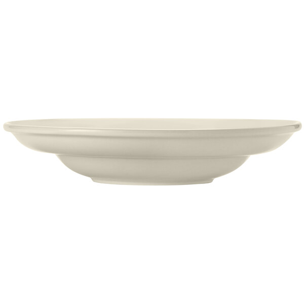 A close-up of a Libbey Porcelana cream white porcelain pasta bowl with a wide rim and rolled edge.