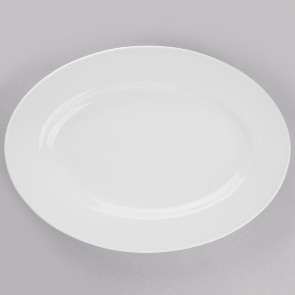 A Libbey Porcelana bright white oval porcelain platter on a gray surface.