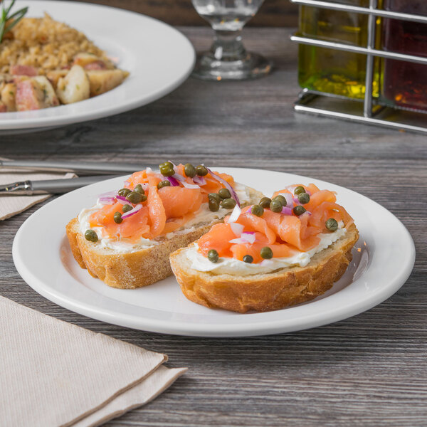 A Libbey Porcelana bright white porcelain plate with food on a table.