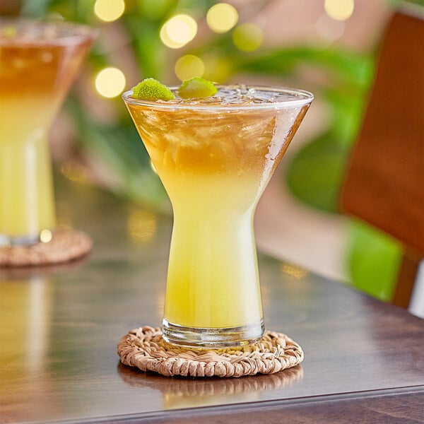 Two Libbey Symbio martini glasses filled with yellow liquid on a table