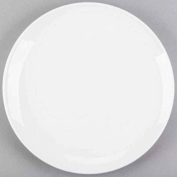 A Libbey Porcelana bright white round porcelain coupe plate on a gray surface.