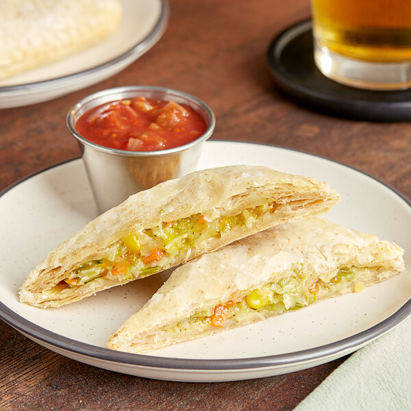 Unbaked Caribbean Food Delights Vegetable Patties on a plate with salsa and a glass of beer.