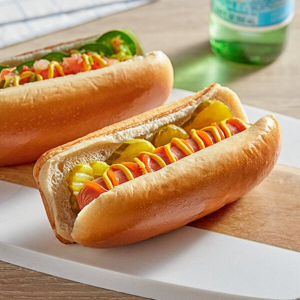 Two Turano hot dogs in buns with mustard and ketchup on a plate.