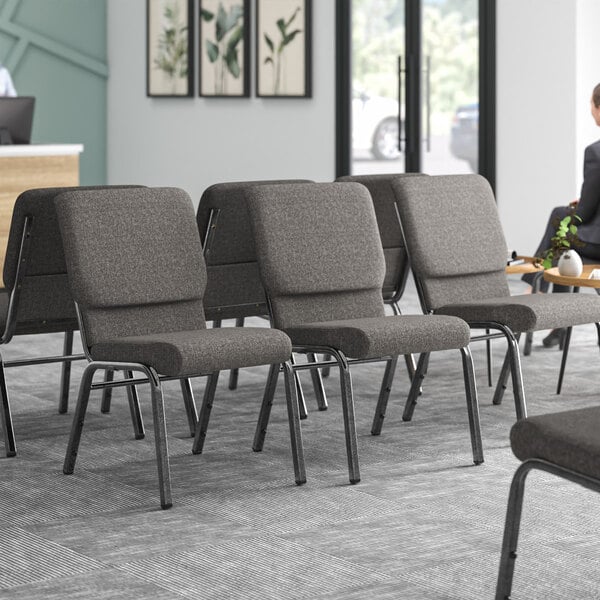 A room with Lancaster Table & Seating Silver Vein Church Chairs with gray fabric.