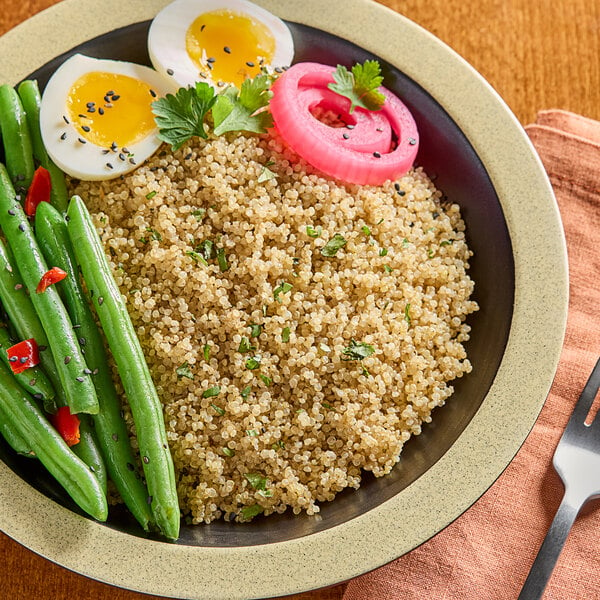 A bowl of quinoa and eggs on a table.