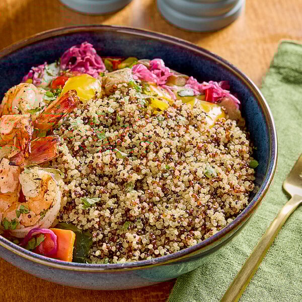 A bowl of tri-color quinoa with shrimp and vegetables.