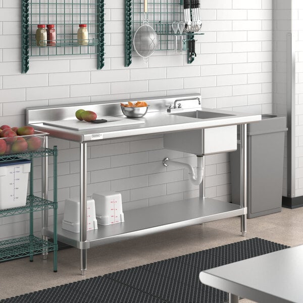 A Regency stainless steel work table with a sink on the right and a shelf.