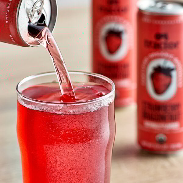 A person pouring Tractor Beverage Co. Organic Strawberry Dragon Fruit juice into a glass.