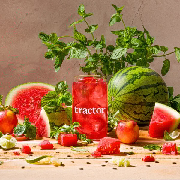 A glass of watermelon and red liquid with watermelon slices.