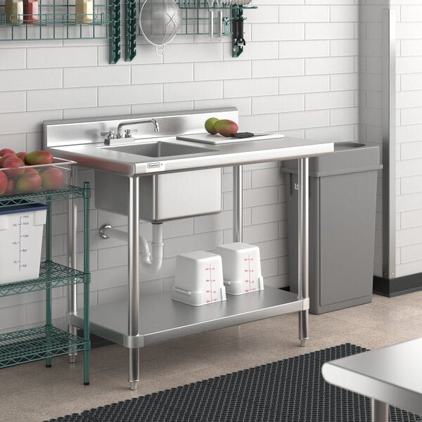 A Regency stainless steel work table with a sink on the left.