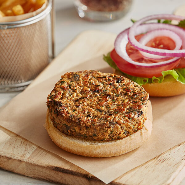 An Abbot's vegan burger with vegetables on a cutting board.