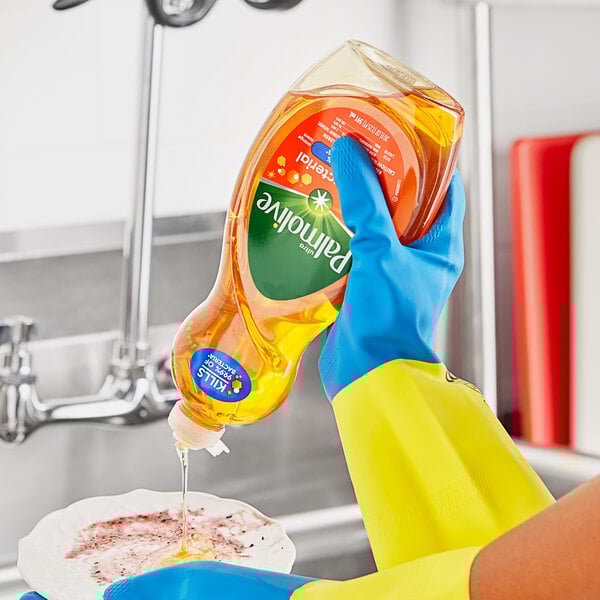 A person in yellow gloves pouring Palmolive dish soap into a bowl.