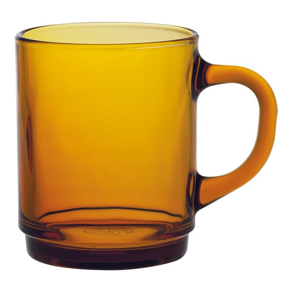 A Duralex stackable amber glass mug with a handle.