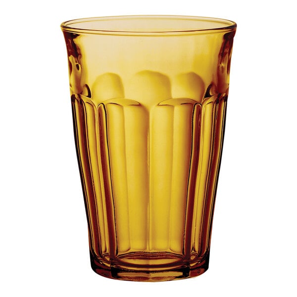 A close up of a Duralex highball glass with a yellow rim.