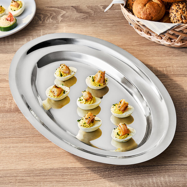 An oval stainless steel serving platter with a reflective finish.