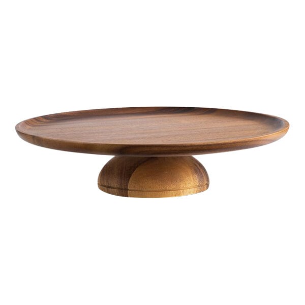 An APS round acacia cake stand with a pedestal on a table.