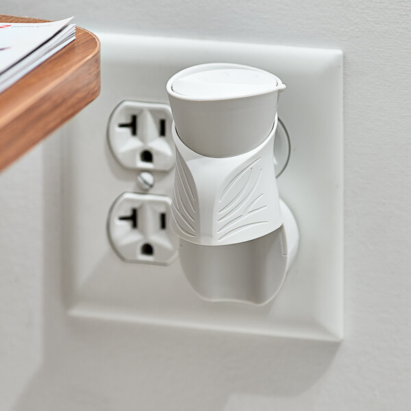 A white Air Wick scented oil warmer plugged into an outlet.