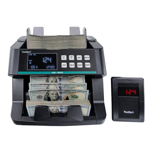 A black electronic Kolibri bill counter with a digital display counting money.