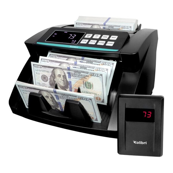 A black Kolibri bill counter with money in it.