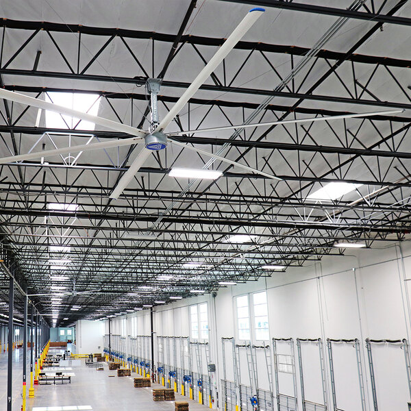 A large white Patterson V-Series 16' HVLS ceiling fan installed in a warehouse.