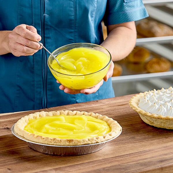 A person holding a bowl of Henry & Henry Spun Gold Lemon Pastry Filling.