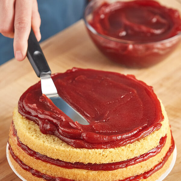 A person cutting a cake with a knife.