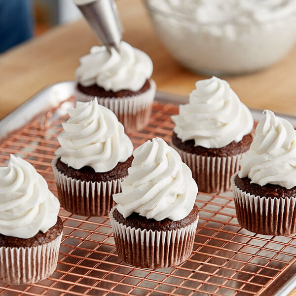 Cupcakes with Brill Vanilla Old Fashioned Buttercreme frosting on a metal cooling rack.