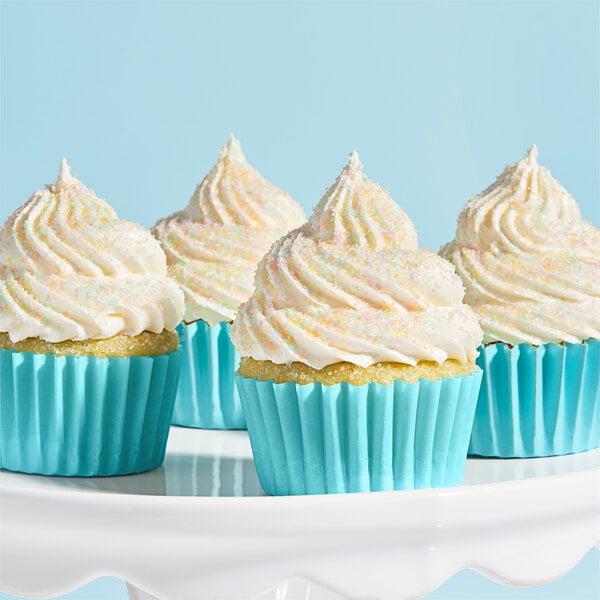 A group of cupcakes with blue frosting and Adourne Pastel Rainbow Sanding Sugar on top.