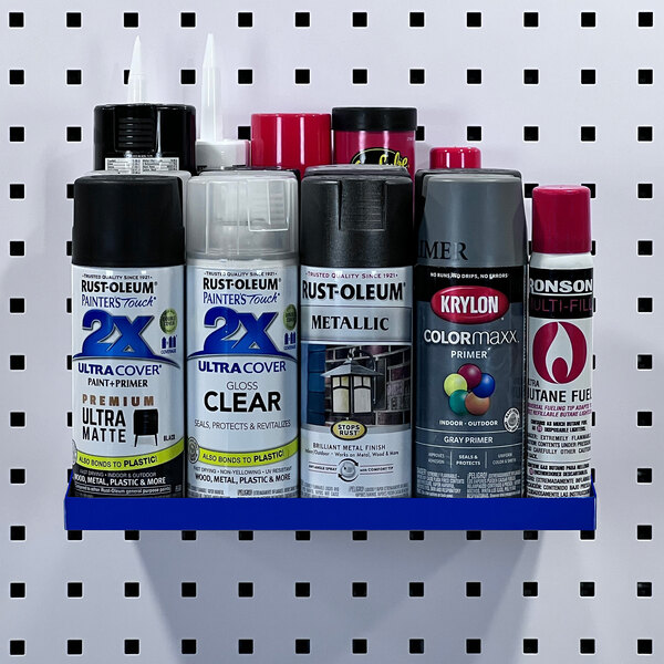 A blue Triton Products steel shelf on a pegboard with spray paint cans on it.