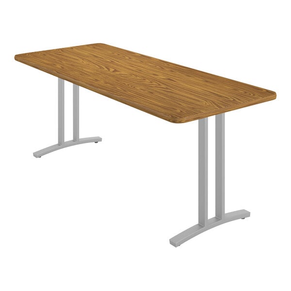 A rectangular Correll table with a medium oak finish and metal legs.
