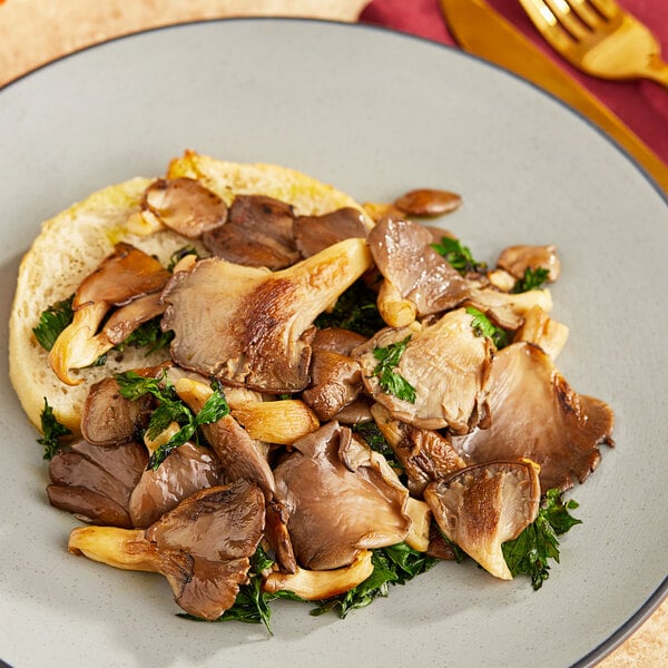 A plate of food with Fresh Oyster Mushrooms and kale on top of bread.