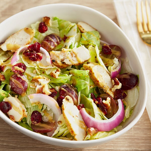 A bowl of chopped Romaine and Iceberg lettuce salad with chicken and cranberries.