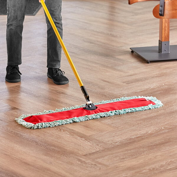 someone using a dry mop on a laminate floor