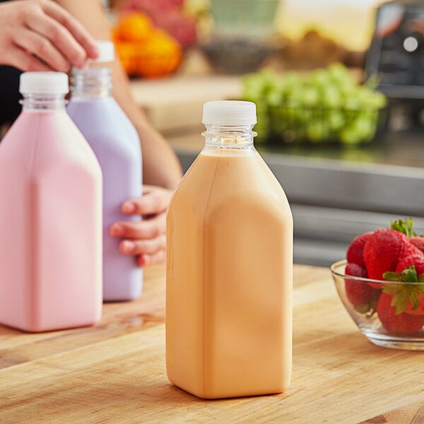 A woman pouring milk into a Square Milkman juice bottle on a table.