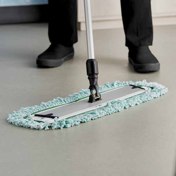 A person using a Lavex 24" microfiber dust mop to clean a floor.