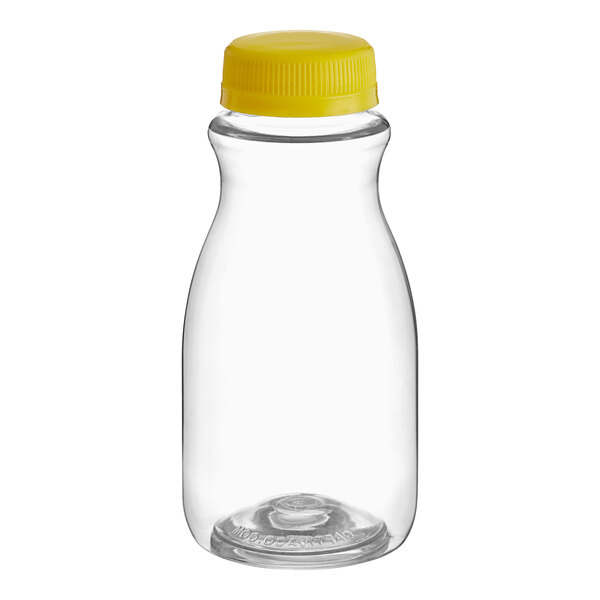 A clear plastic 8 oz. round carafe juice bottle with a yellow cap.