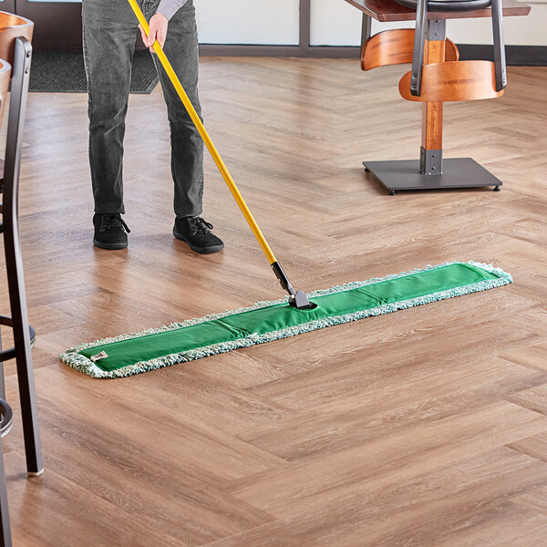 A person mopping the floor with a Lavex microfiber mop pad.
