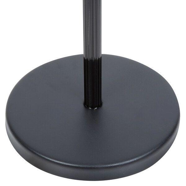 A black round base with a black pole holding a black Aarco hostess sign.