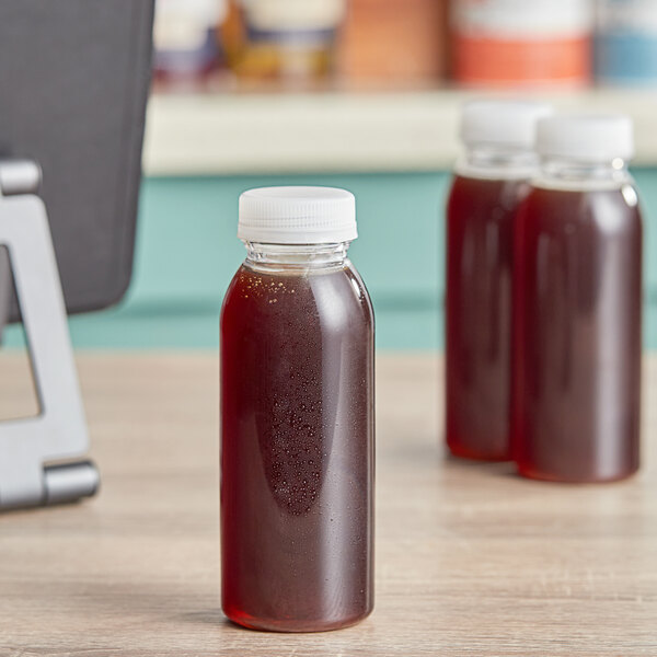 A 4 oz. clear energy bottle of liquid on a table.