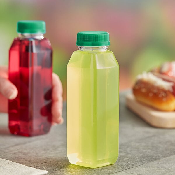 A hand holding a 10 oz. square PET clear juice bottle with green liquid.