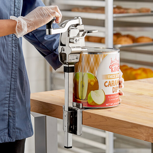 A hand using a Hamilton Beach Heavy-Duty Can Opener to open a can of caramel dip.