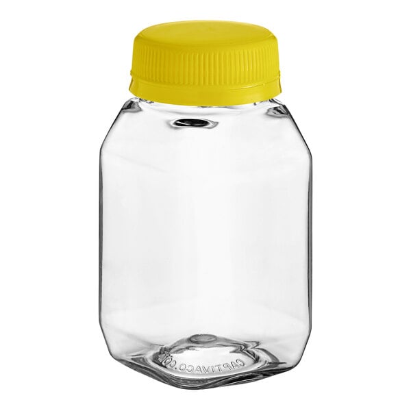 A clear PET square juice bottle with a yellow lid.