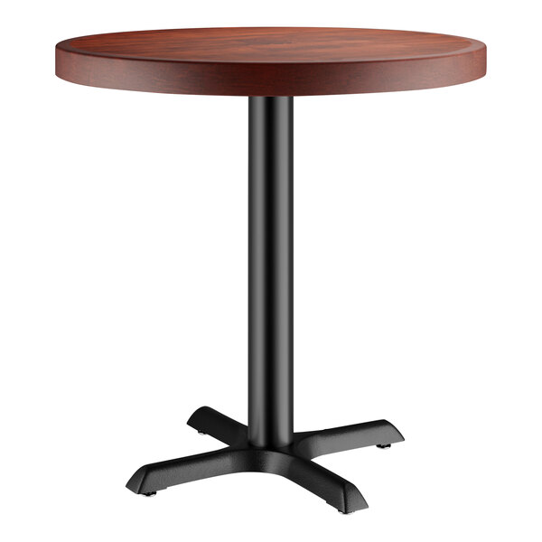 A Lancaster Table & Seating round wooden table with a black base.